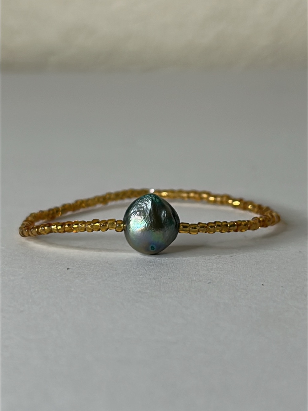 Gold Beaded Bracelet with Iridescent Dark Pearl Center